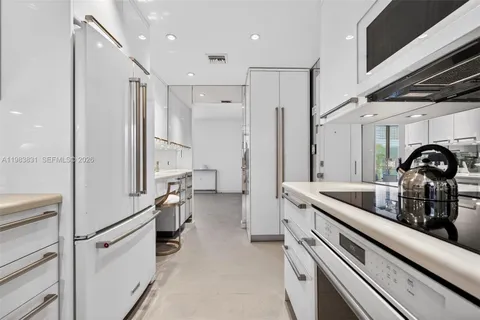 a kitchen with a refrigerator and white cabinets