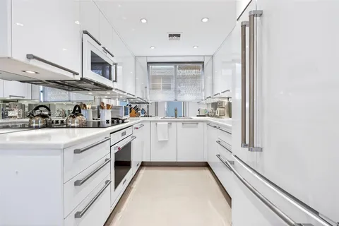a kitchen with white cabinets and white appliances