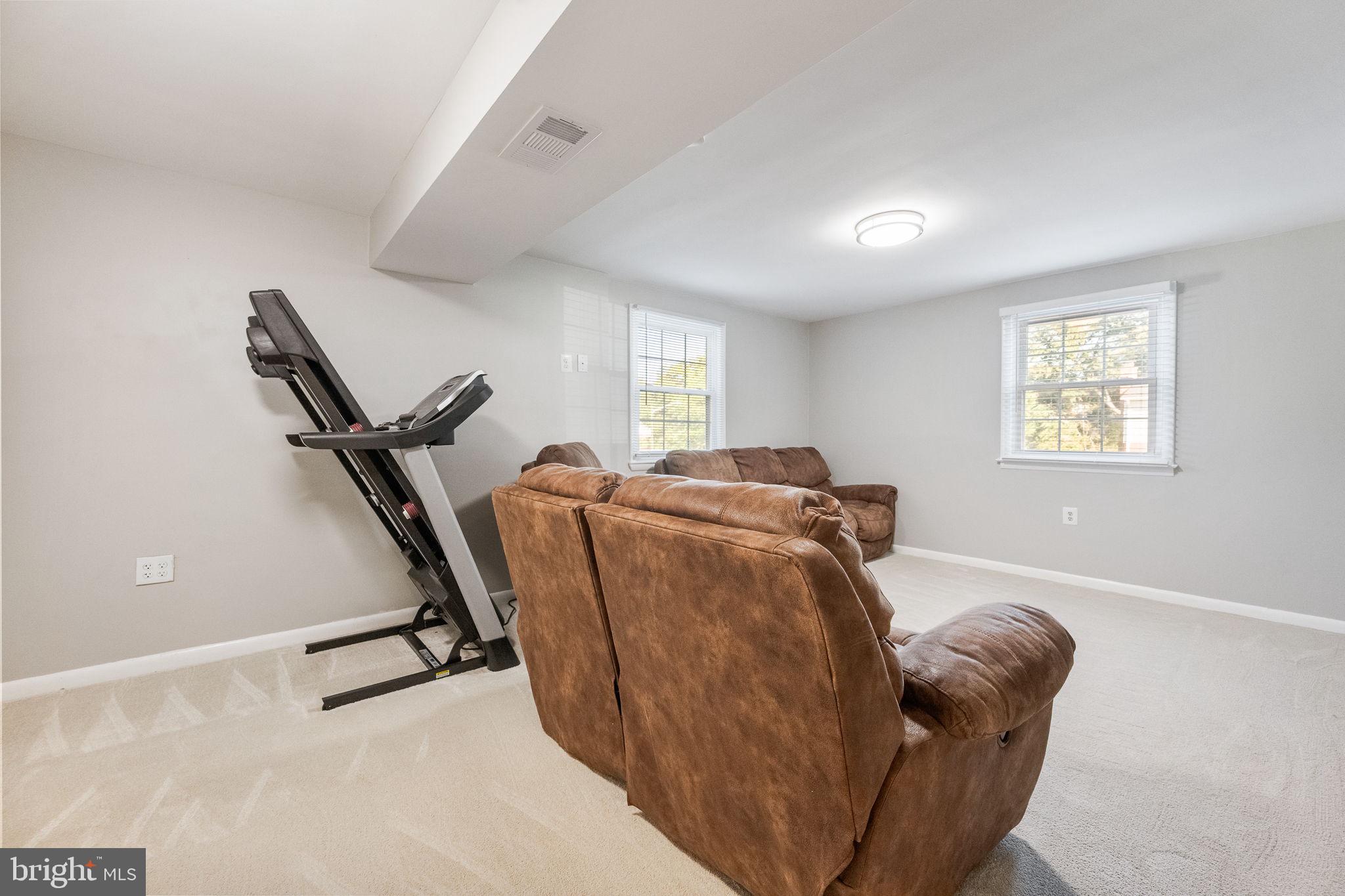 7203 Hadlow Drive Springfield, VA 22152 - Photo 29 of 39 a living room with furniture gym equipment and a window