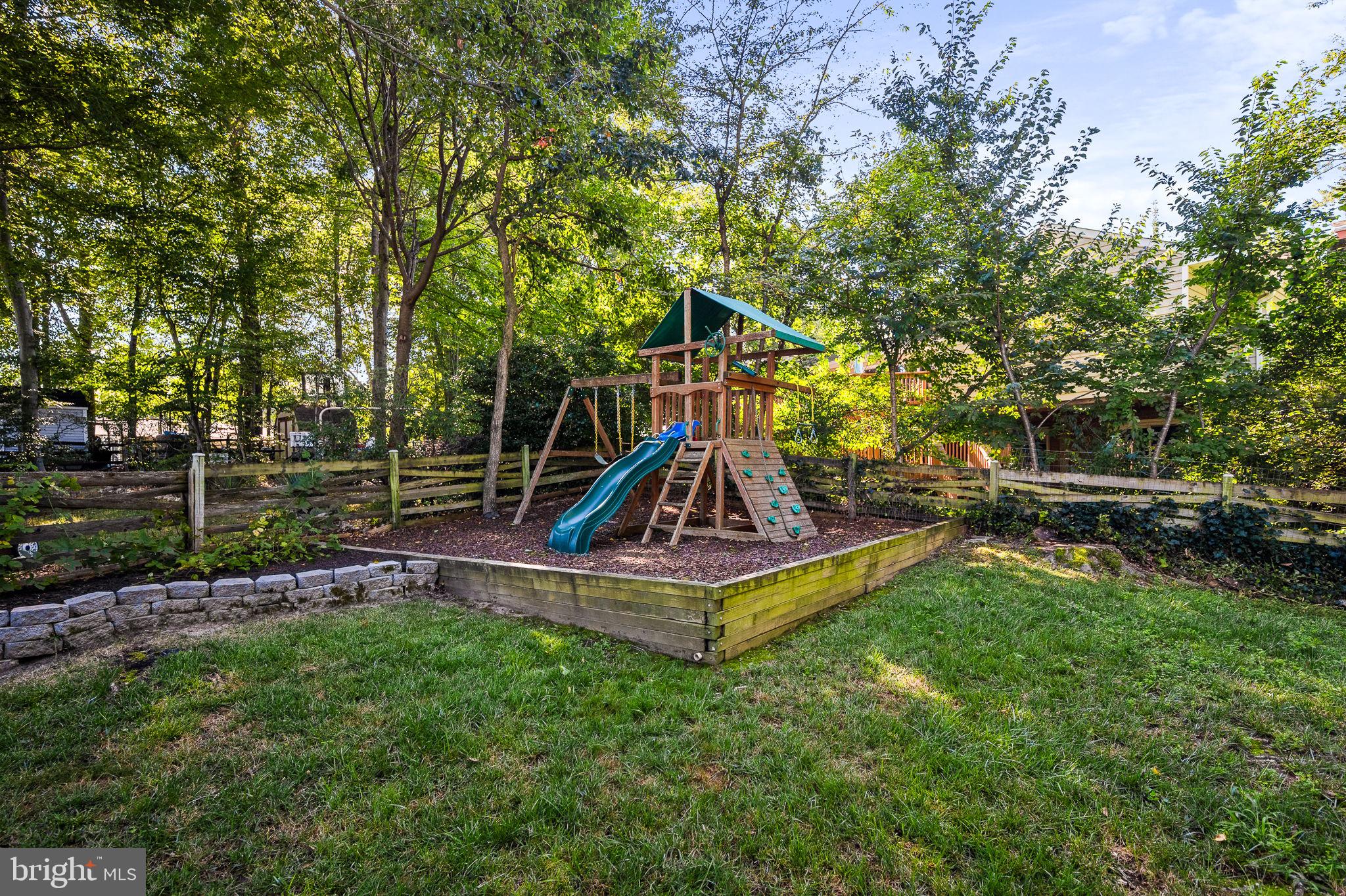 7203 Hadlow Drive Springfield, VA 22152 - Photo 32 of 39 a view of a backyard with a slide trees and wooden fence