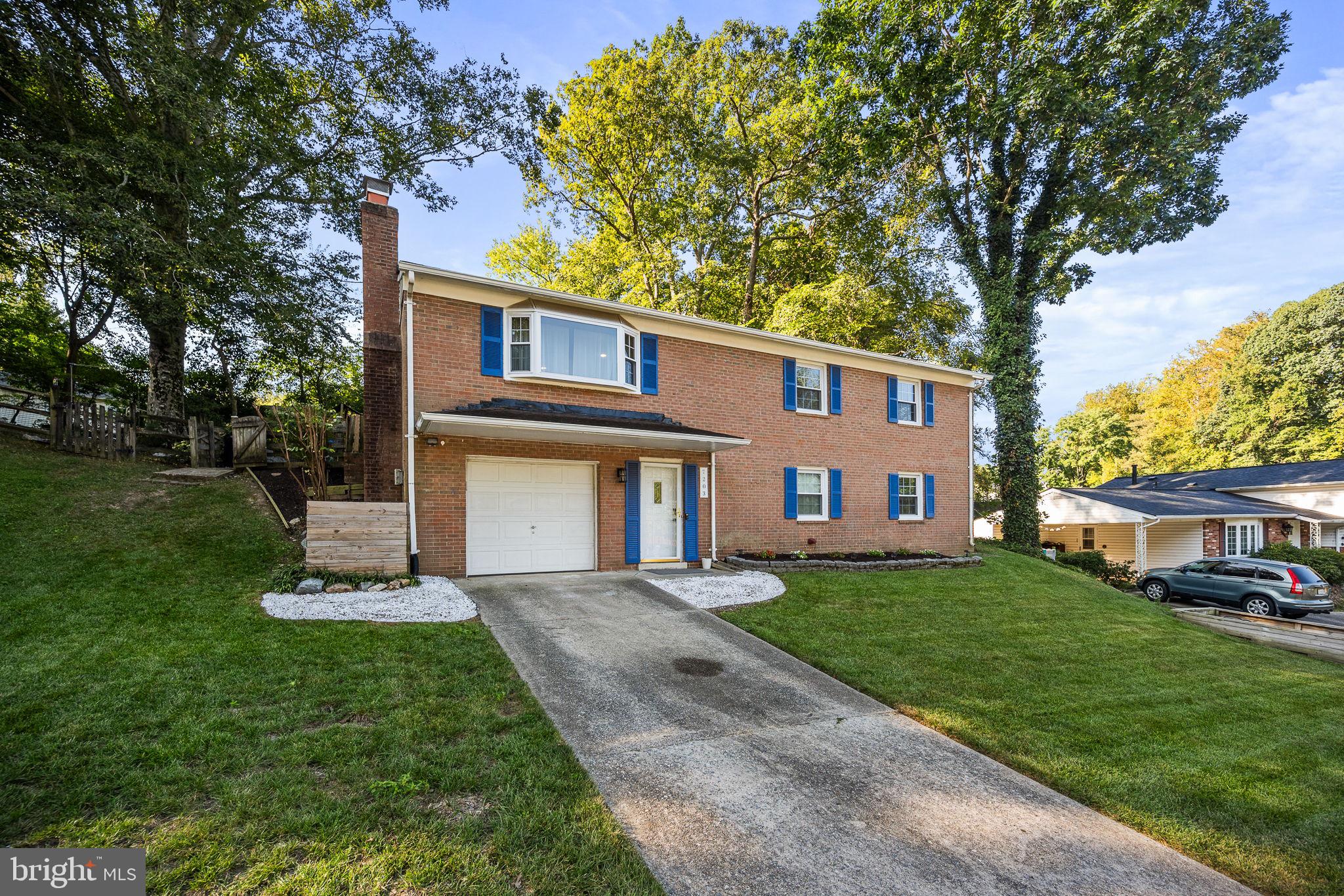 7203 Hadlow Drive Springfield, VA 22152 - Photo 4 of 39 a front view of a house with a yard and trees