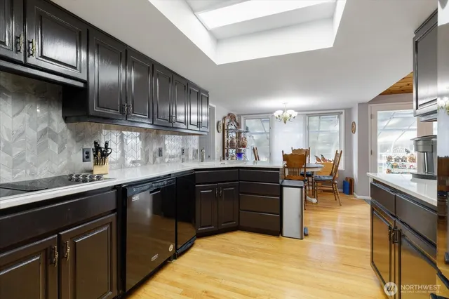 a kitchen with stainless steel appliances granite countertop a sink dishwasher a stove and cabinets with wooden floor