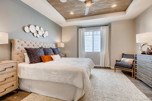 a bedroom with a large bed a chandelier and a couch