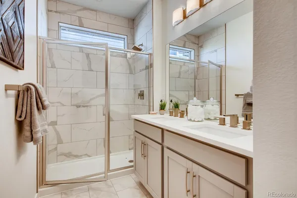 a bathroom with a granite countertop sink a mirror and shower