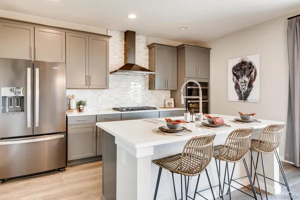 a kitchen with stainless steel appliances kitchen island granite countertop a dining table and chairs