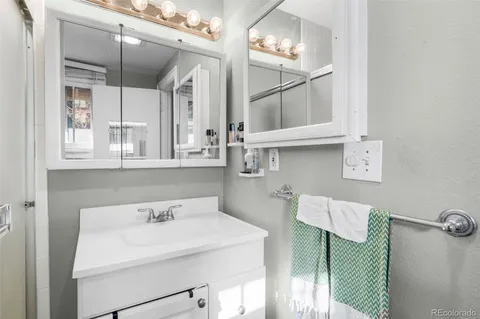 a bathroom with a sink a light fixture and a mirror