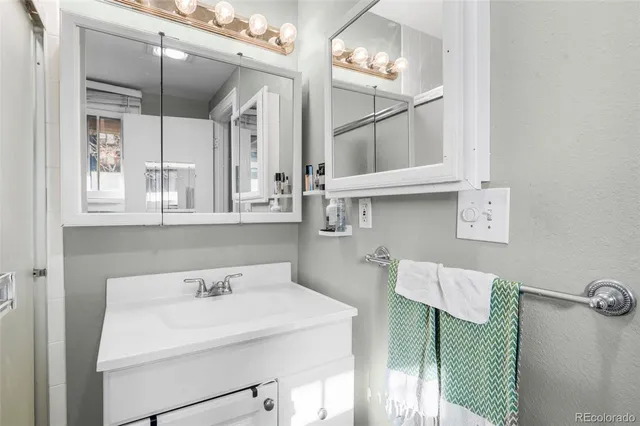 a bathroom with a sink a light fixture and a mirror