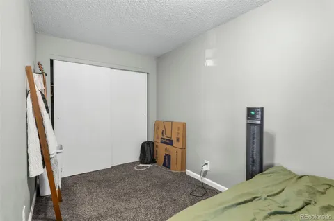 a bedroom with a bed and a flat tv screen on a dresser