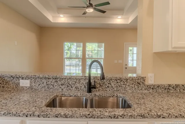 a kitchen with a sink a counter top space cabinets and stainless steel appliances