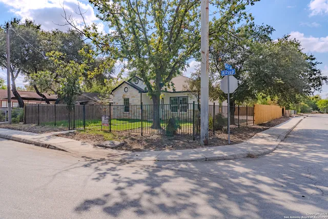 a backyard of a house with fountain and large trees
