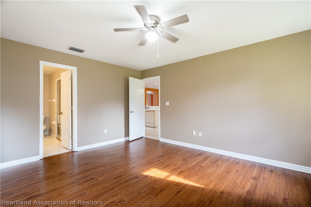 309 Lark Terrace Sebring, FL 33872 - Photo 14 of 32 an empty room with wooden floor and a ceiling fan