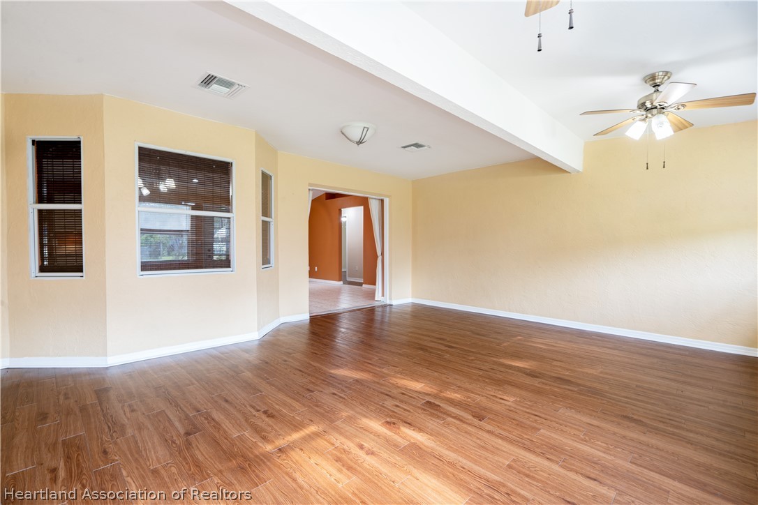 309 Lark Terrace Sebring, FL 33872 - Photo 17 of 32 a view of an empty room with window and wooden floor