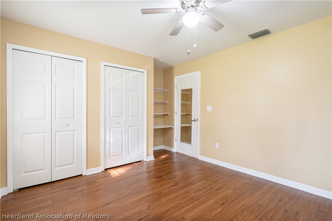 309 Lark Terrace Sebring, FL 33872 - Photo 19 of 32 an empty room with wooden floor closet and windows