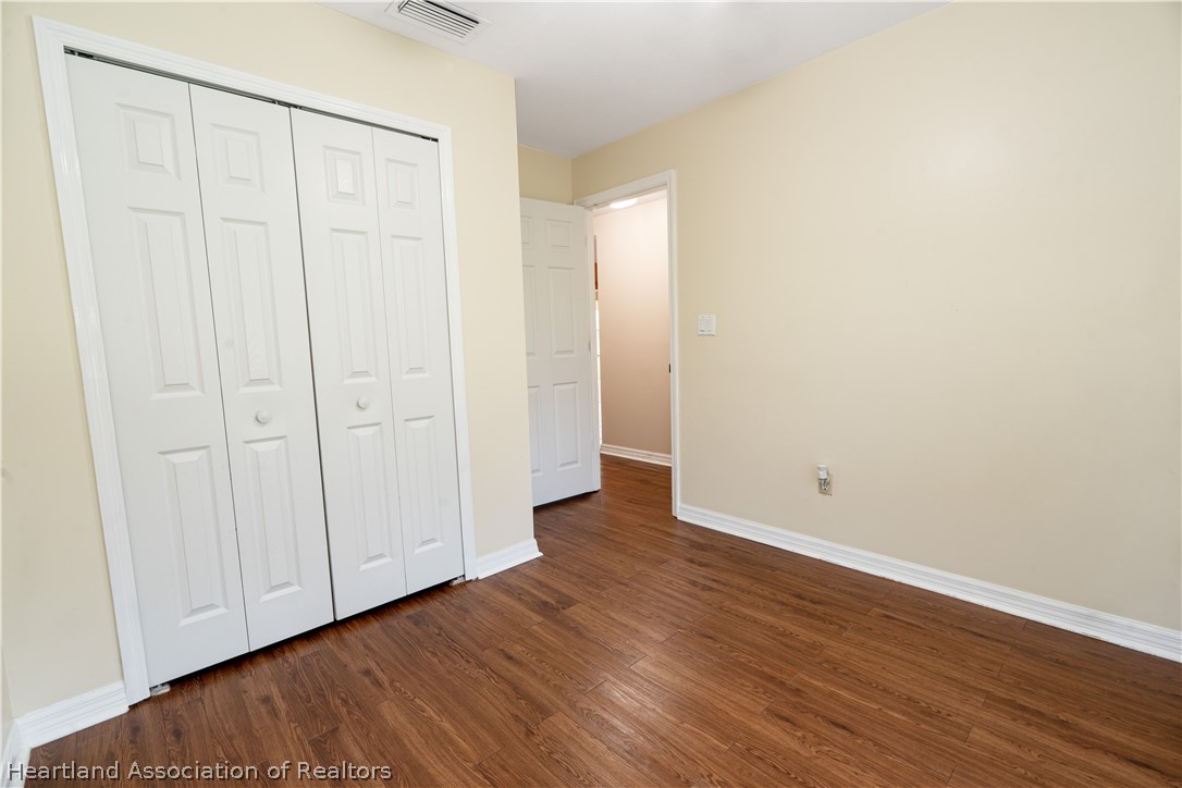 309 Lark Terrace Sebring, FL 33872 - Photo 23 of 32 a view of an empty room with wooden floor