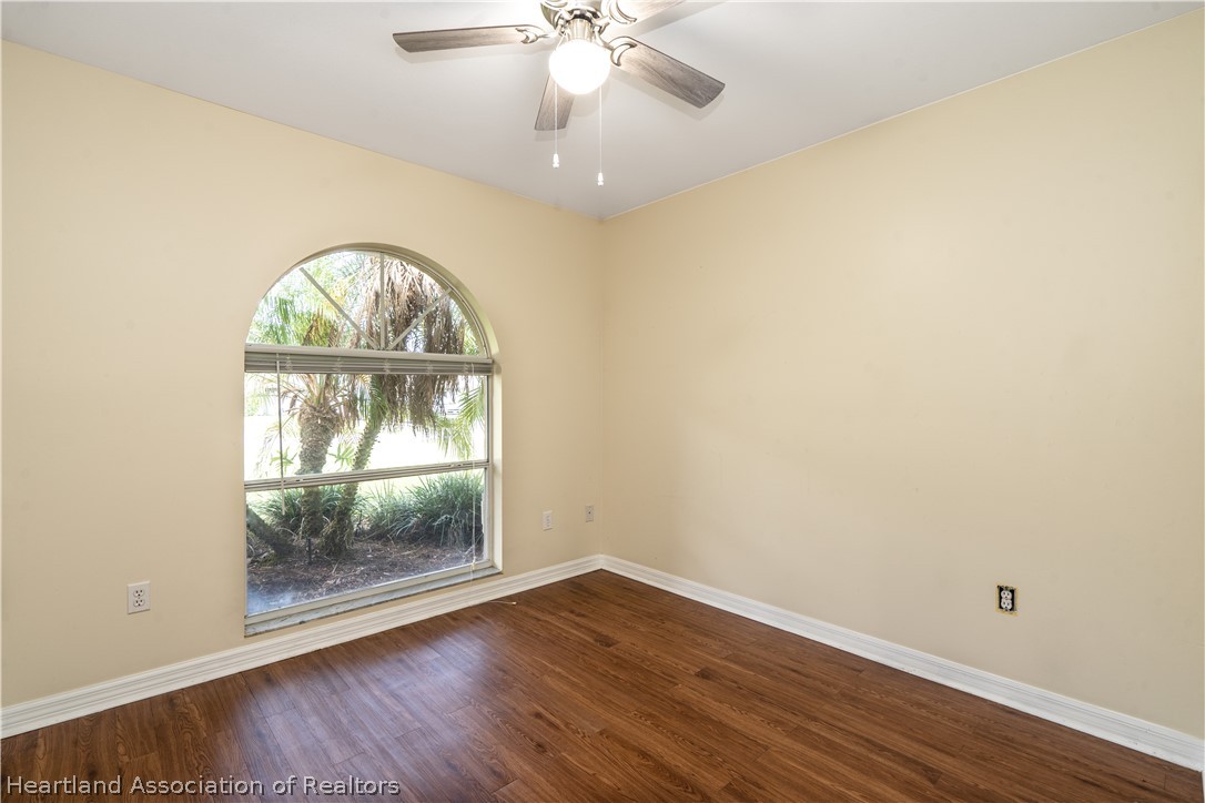 309 Lark Terrace Sebring, FL 33872 - Photo 24 of 32 an empty room with wooden floor fan and window