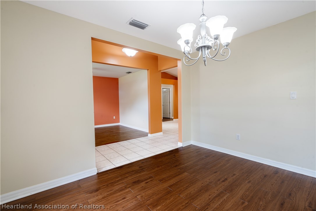 309 Lark Terrace Sebring, FL 33872 - Photo 4 of 32 a view of an empty room with wooden floor