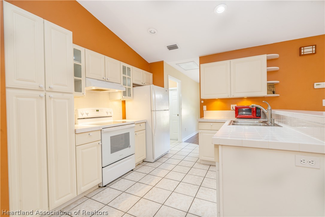 309 Lark Terrace Sebring, FL 33872 - Photo 8 of 32 a kitchen with stainless steel appliances a stove a sink and a refrigerator