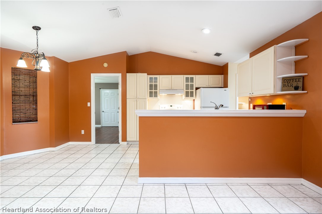 309 Lark Terrace Sebring, FL 33872 - Photo 10 of 32 a kitchen with stainless steel appliances granite countertop a sink a stove and a refrigerator