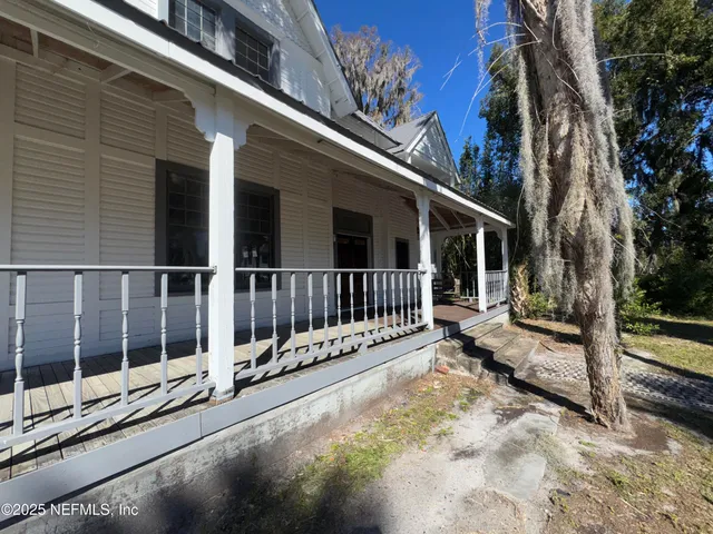 a view of a house with wooden floor next to a yard