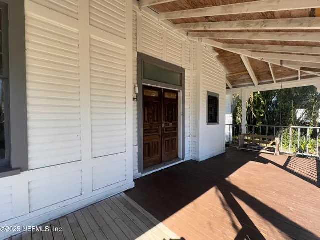 a view of a balcony with chairs and wooden floor