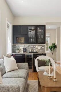 a living room with furniture kitchen view and a chandelier