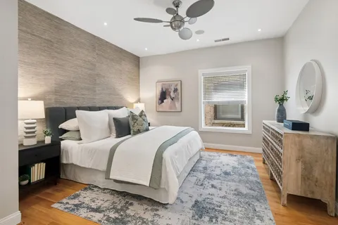 a spacious bedroom with a bed table and a window