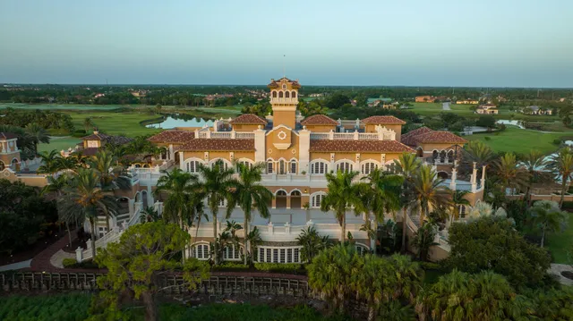 an aerial view of a house with a garden and lake view