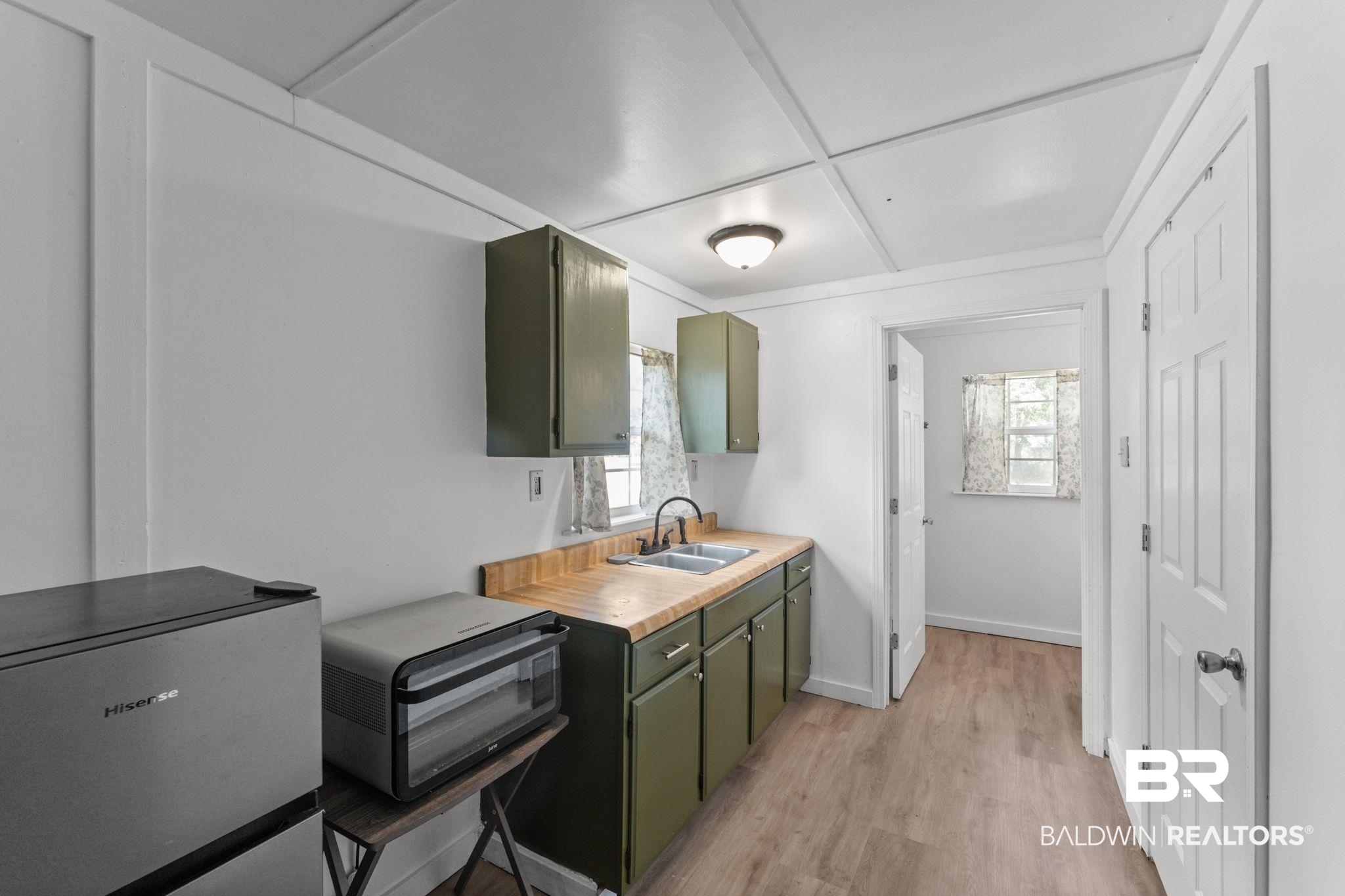 10785 Gregg Road Semmes, AL 36575 - Photo 35 of 35 Kitchen featuring green cabinetry, refrigerator, healthy amount of natural light, and light wood finished floors