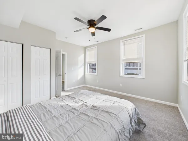 a bedroom with a large bed chandelier and a window