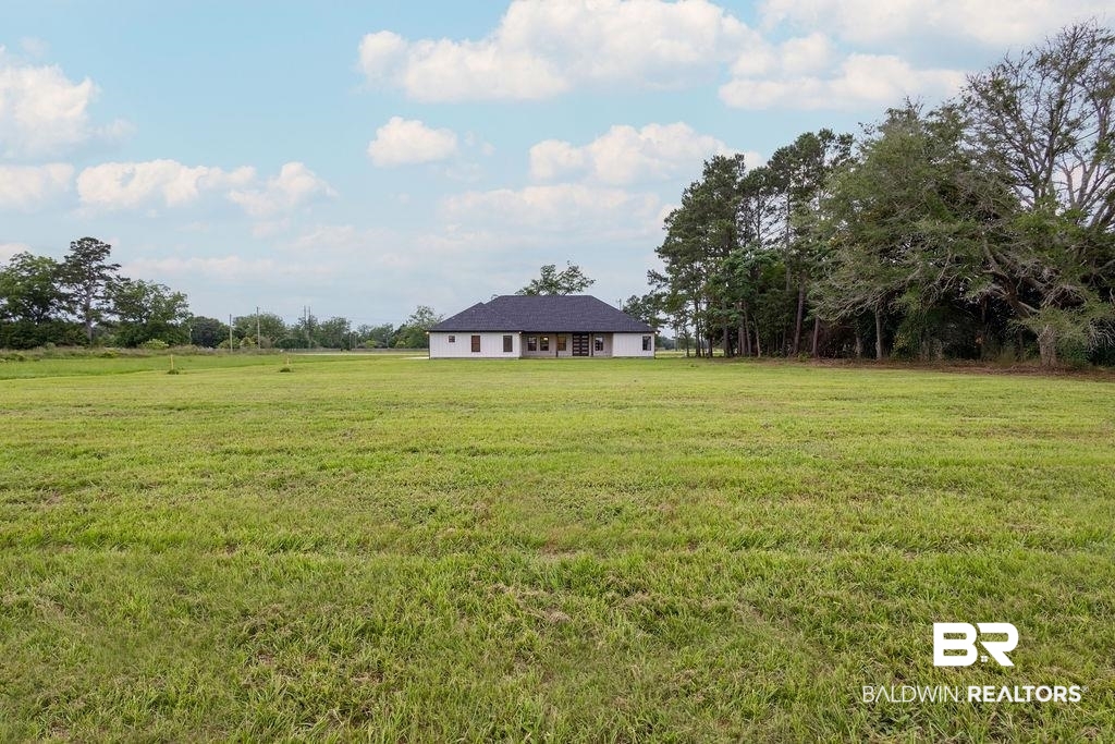 13066 Gopher Court Elberta, AL 36530 - Photo 25 of 38 Expansive grassy lot with a single-story residence featuring a dark shingle roof and light-colored siding