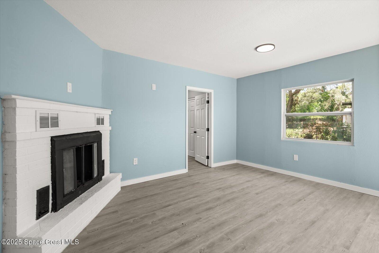 1436 Melrose Street Cocoa, FL 32922 - Photo 11 of 28 an empty room with windows and fireplace