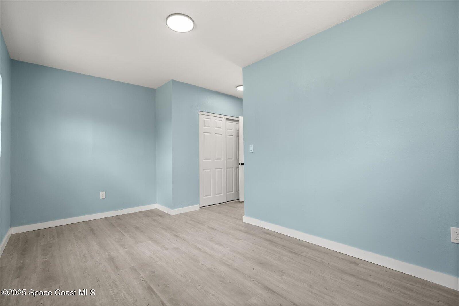 1436 Melrose Street Cocoa, FL 32922 - Photo 16 of 28 a view of an empty room with wooden floor and closet