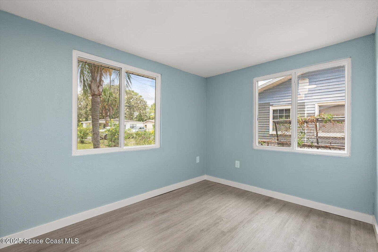 1436 Melrose Street Cocoa, FL 32922 - Photo 19 of 28 a view of an empty room with wooden floor and a window