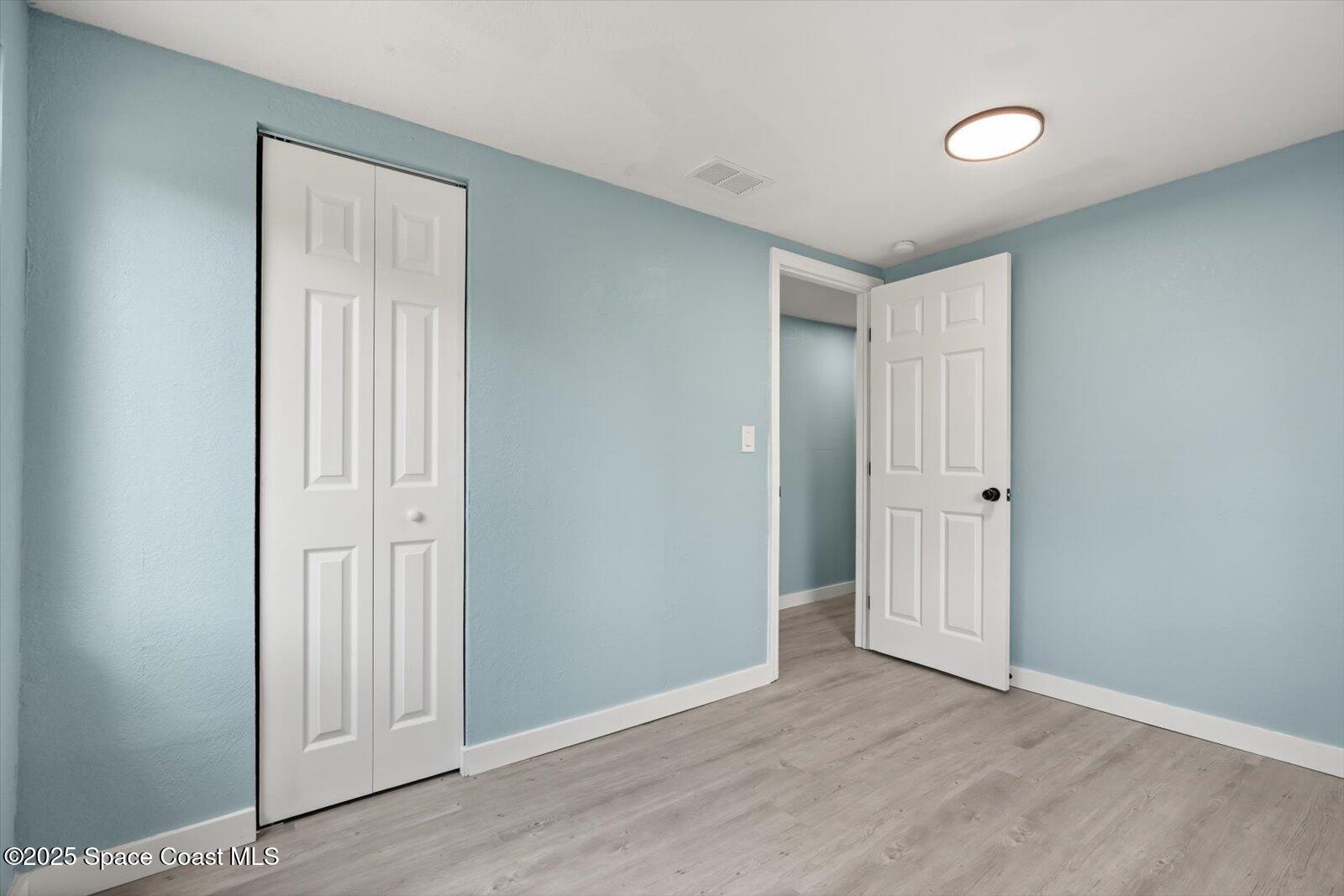 1436 Melrose Street Cocoa, FL 32922 - Photo 20 of 28 an empty room with wooden door and windows