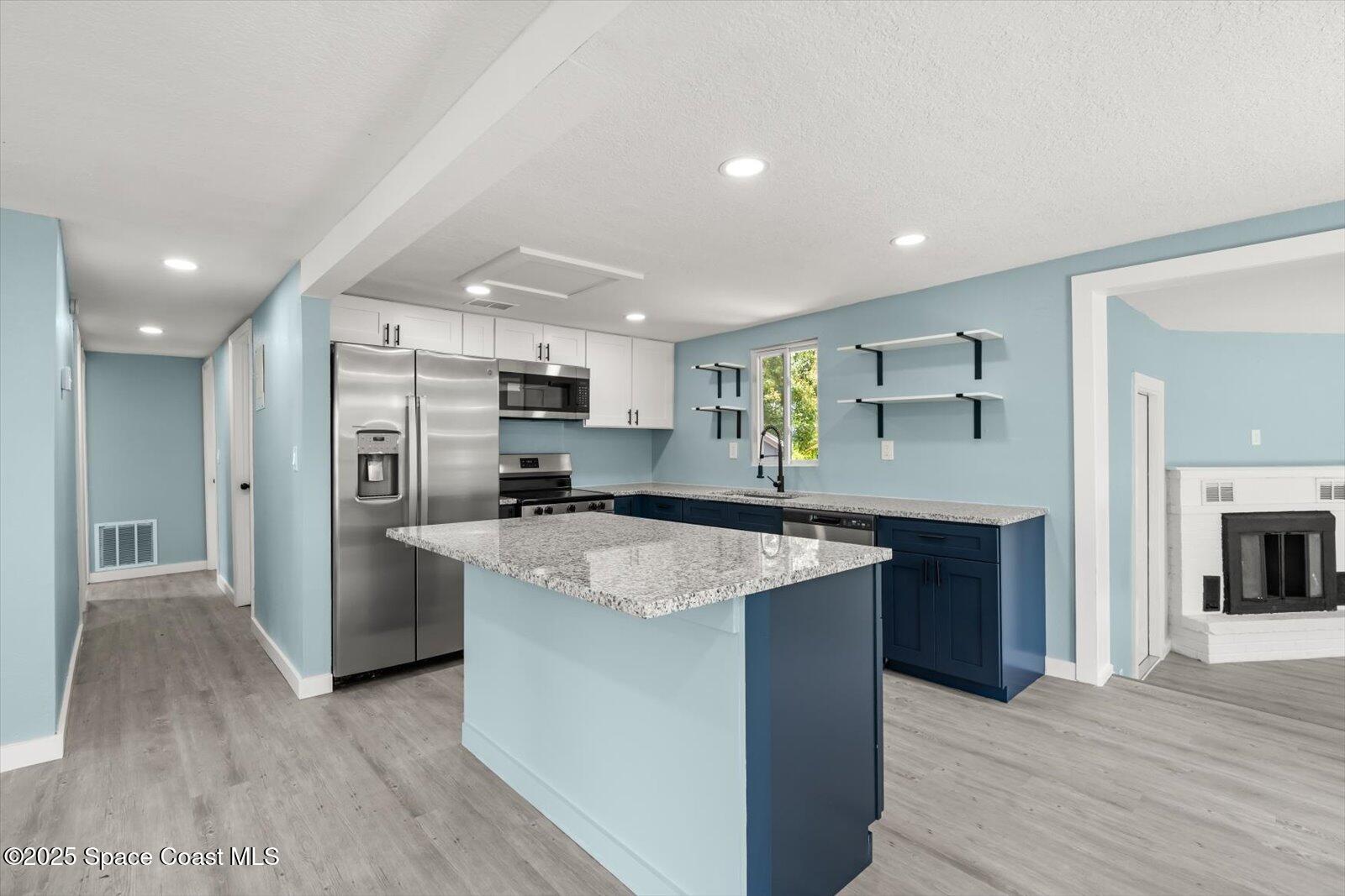 1436 Melrose Street Cocoa, FL 32922 - Photo 3 of 28 a kitchen with stainless steel appliances granite countertop a refrigerator a sink dishwasher and a oven with wooden floor