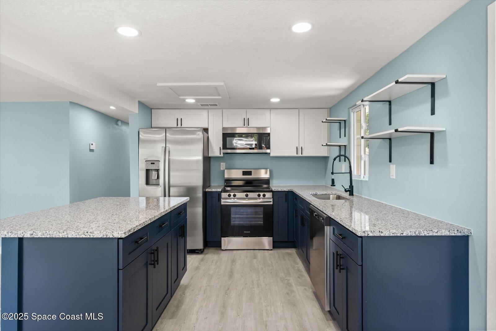 1436 Melrose Street Cocoa, FL 32922 - Photo 4 of 28 a kitchen with kitchen island granite countertop a sink stove and refrigerator