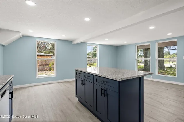 a kitchen with granite countertop a sink a wooden floor and a stove