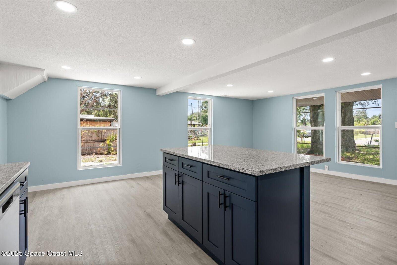 1436 Melrose Street Cocoa, FL 32922 - Photo 5 of 28 a kitchen with granite countertop a sink a wooden floor and a stove