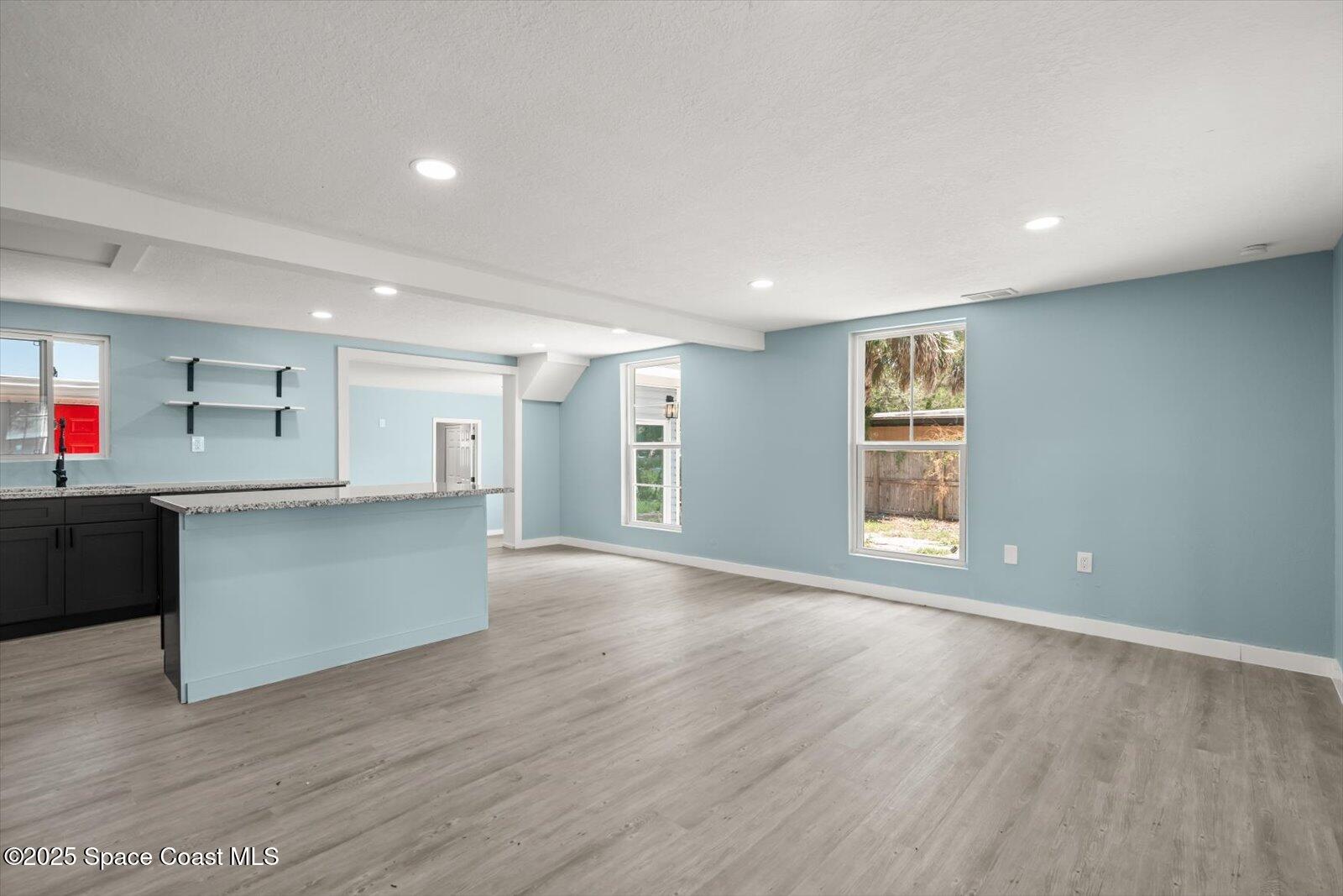 1436 Melrose Street Cocoa, FL 32922 - Photo 7 of 28 a view of an empty room with wooden floor and windows