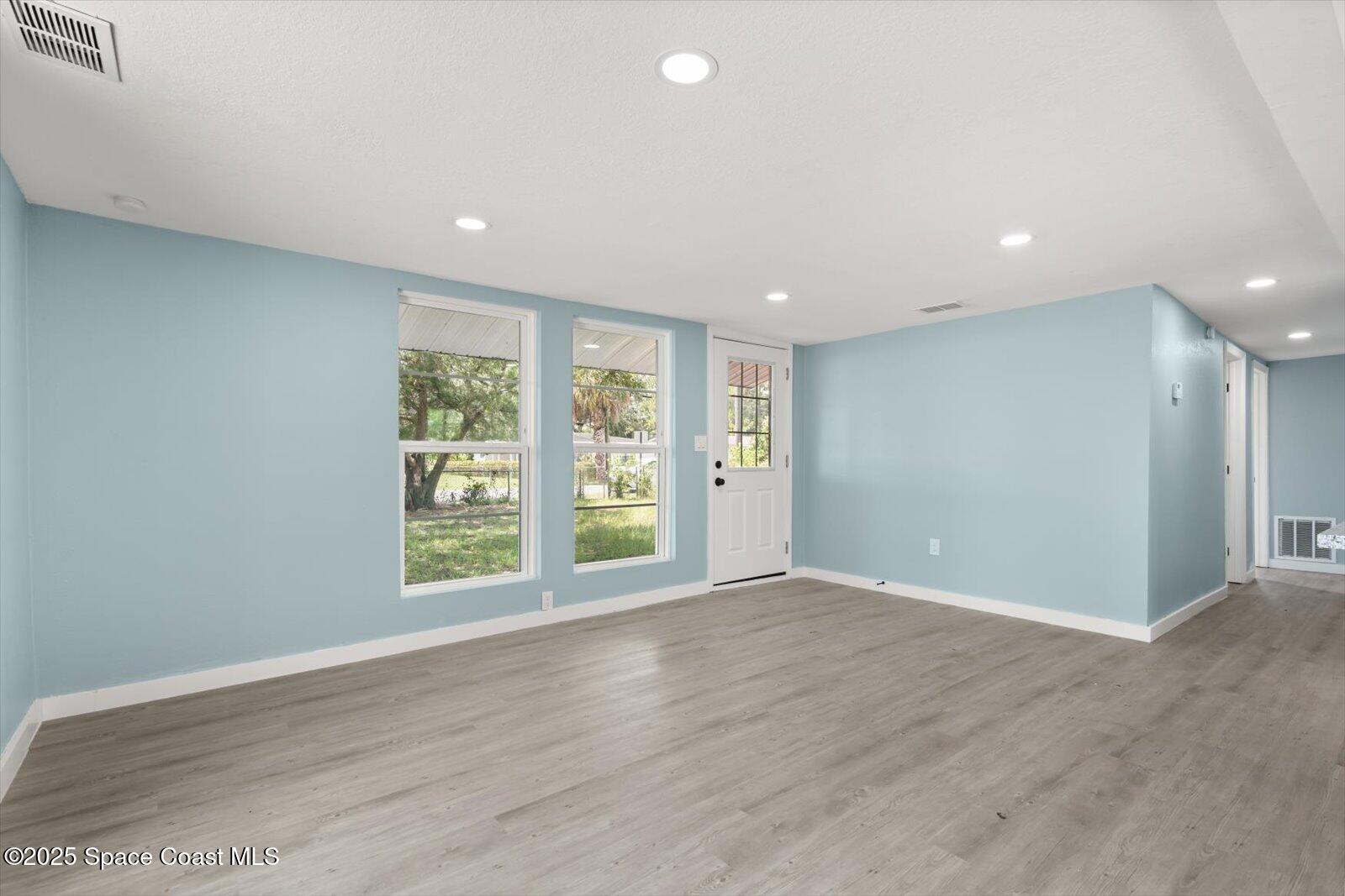 1436 Melrose Street Cocoa, FL 32922 - Photo 8 of 28 an empty room with wooden floor and windows