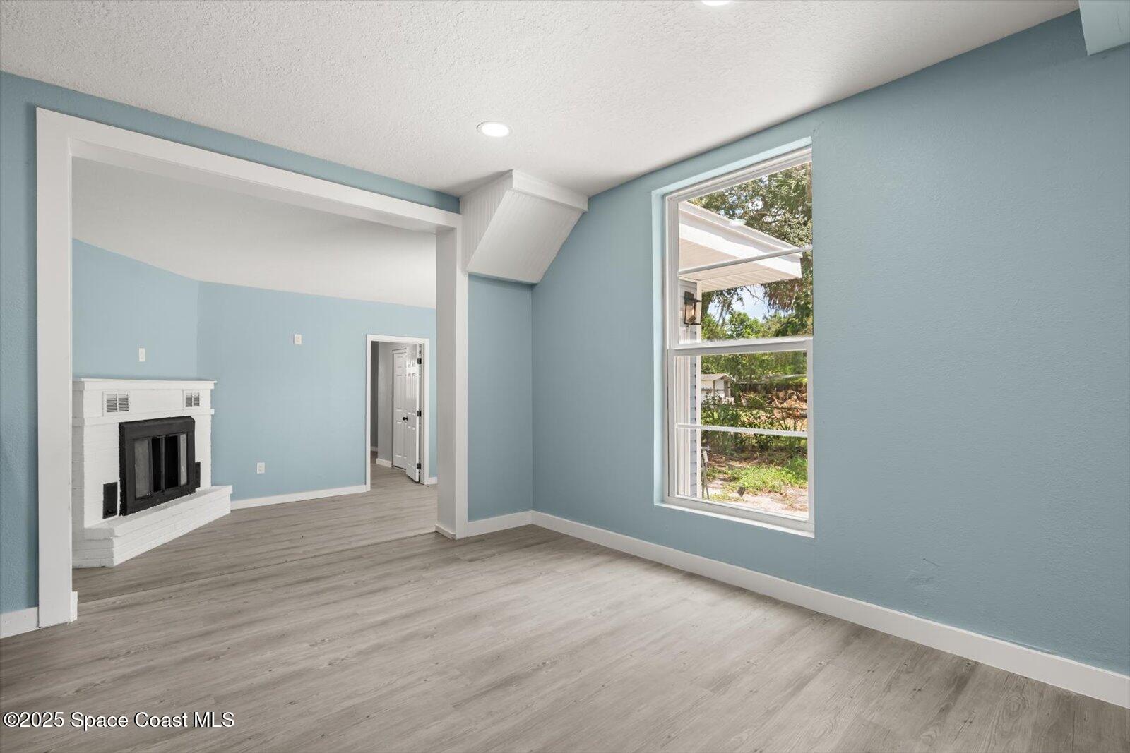 1436 Melrose Street Cocoa, FL 32922 - Photo 9 of 28 an empty room with windows and fireplace