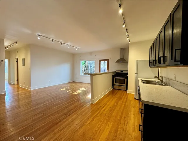 a view of a kitchen with wooden floor and a sink