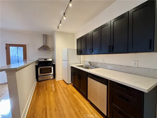 a kitchen with granite countertop stainless steel appliances and wooden cabinets