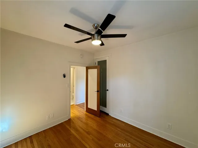 a view of a room with wooden floor and a ceiling fan