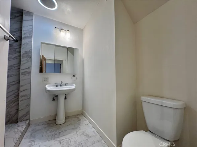 a bathroom with a sink toilet and mirror