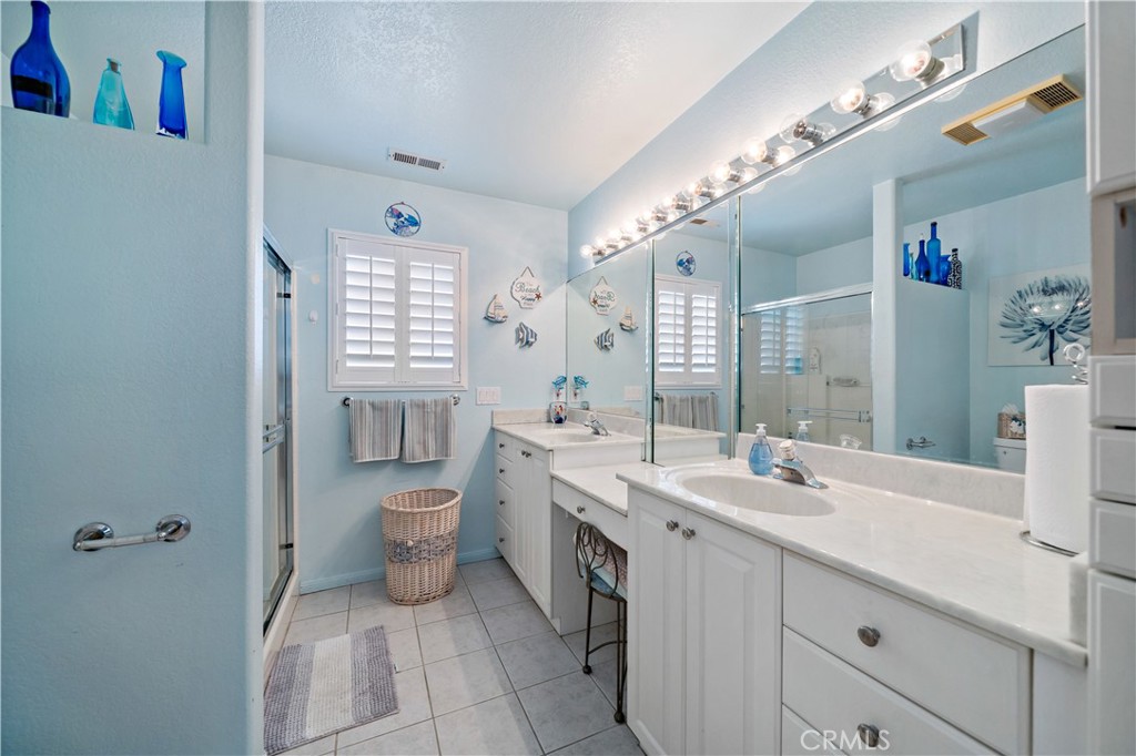 6536 Oceanview Drive, Unit T Carlsbad, CA 92011 - Photo 27 of 44 a spacious bathroom with a double vanity sink a toilet and a mirror