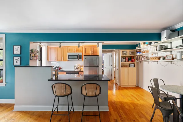 a kitchen with stainless steel appliances granite countertop a table and chairs in it