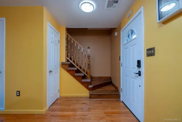a view of a hallway with wooden floor and staircase