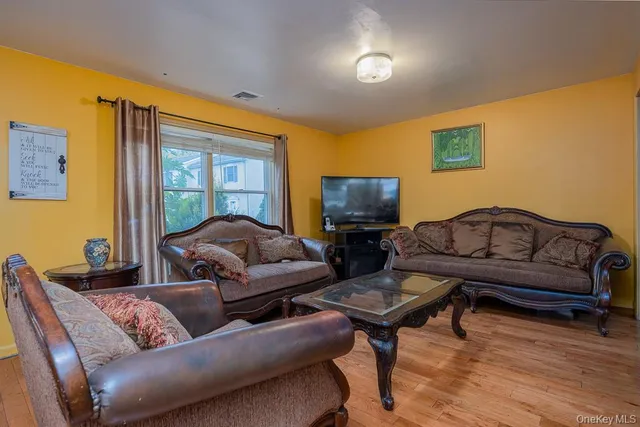 a living room with furniture a flat screen tv and a window