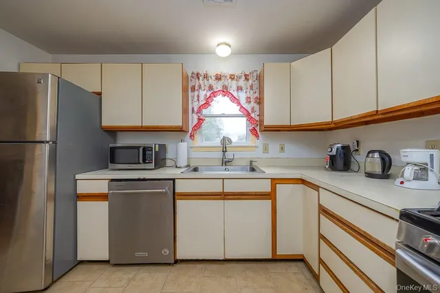 a kitchen with cabinets appliances a sink and a counter top space